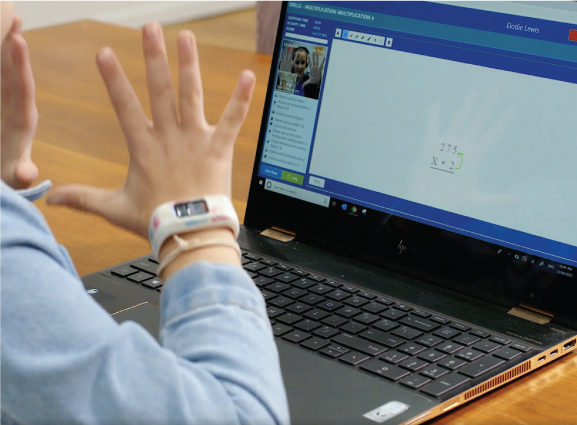 Student working on computer raising hands.